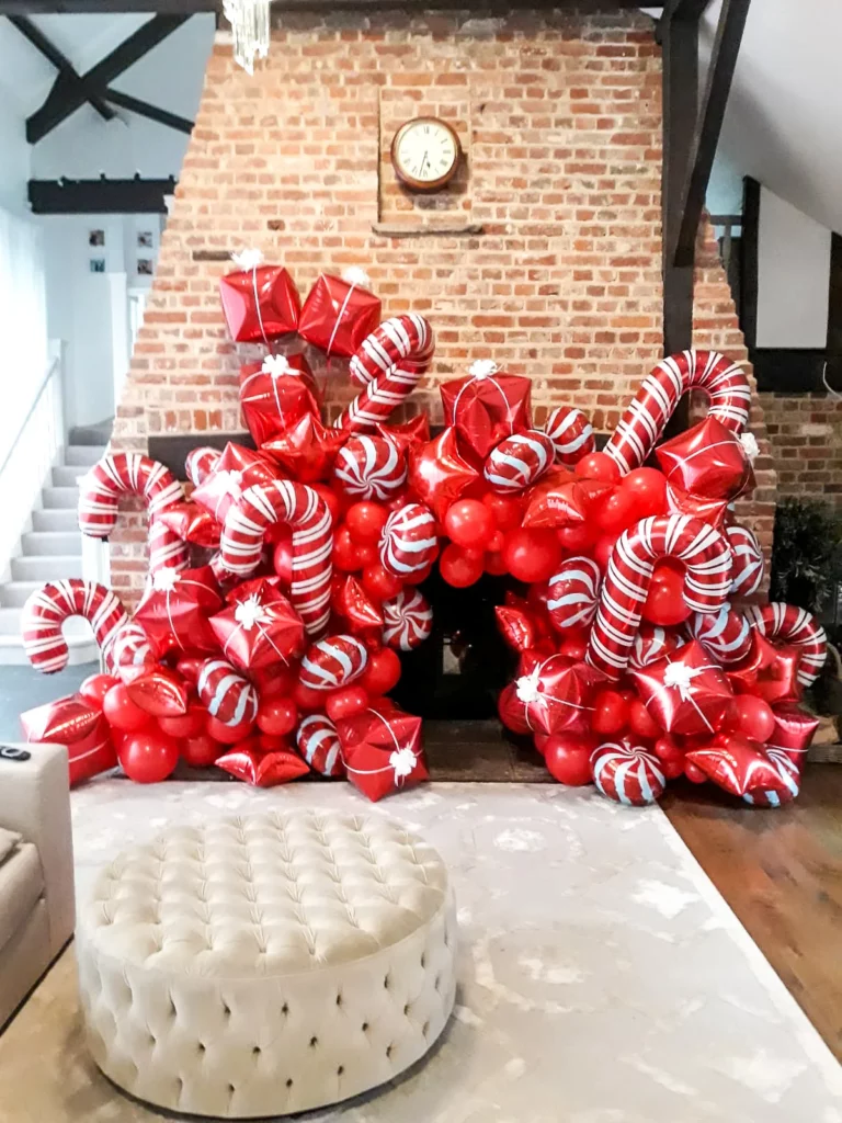 Christmas party balloon arch featuring balloons in Santa candy shades of red and white latex column balloons.
