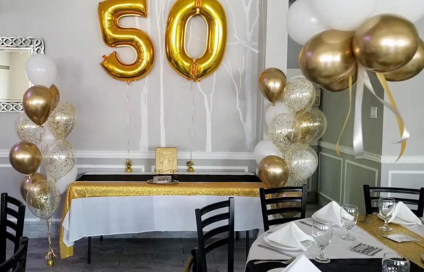 Gold and white latex balloons with confetti and large 50 Number balloon for a 50th celebration.