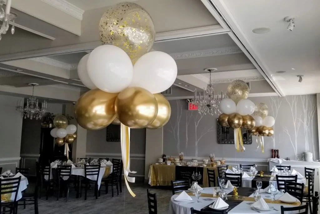 Elegant gold and white balloon centerpieces adorned with stunning gold confetti balloons.