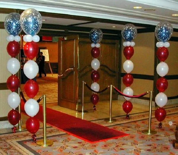 Festive red, white, and blue balloon column adorned with mini balloons for a vibrant party atmosphere.