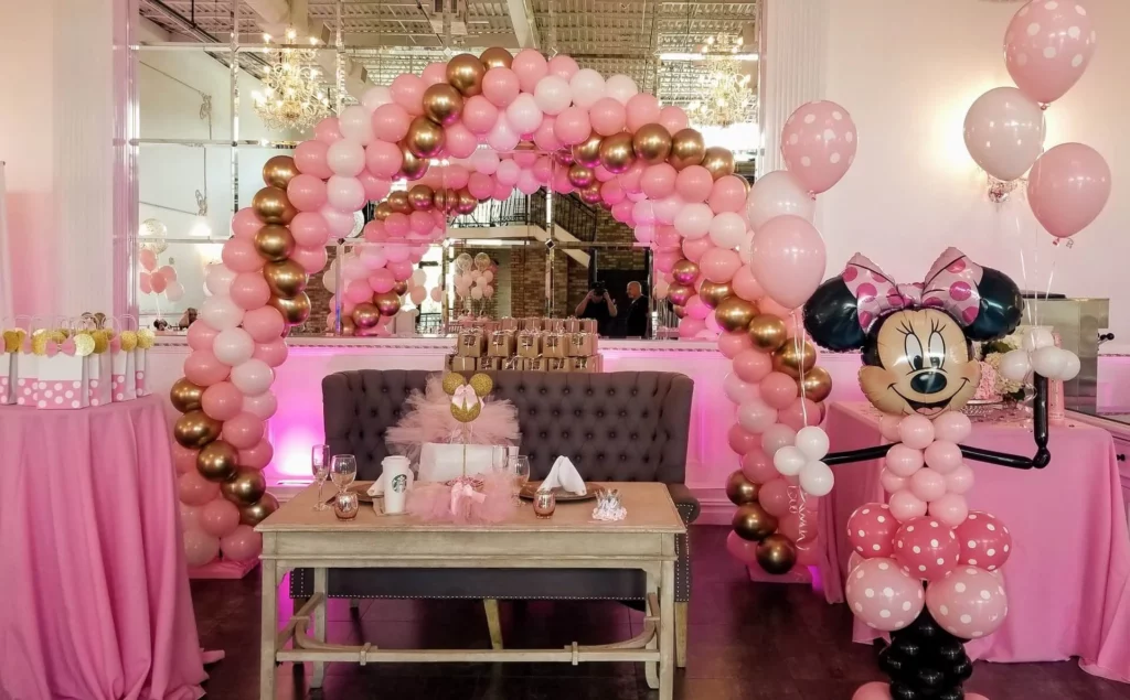Unique balloon arrangement from Balloons Lane in Manhattan, featuring chrome gold, light pink, and pink balloons, along with Minnie Mouse pink latex arch balloons.