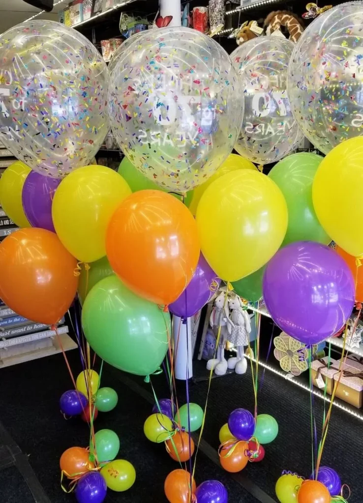Party decorations at Balloons Lane feature Lime Green, Orange, Yellow and Purple latex balloons, colorful confetti-filled balloons, and a mix of colored latex balloons.