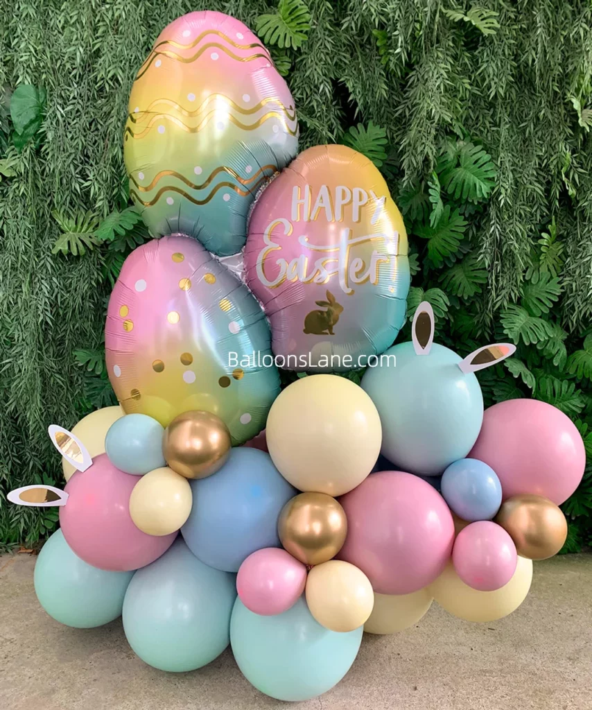 A cheerful Easter customized egg balloon surrounded by pink, green, and peach balloon centerpieces/clusters in Brooklyn.