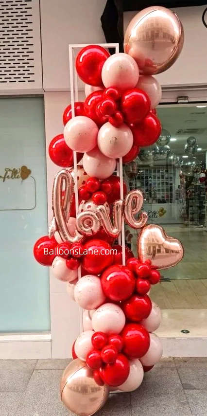 Celebrate Valentine's Day in Staten Island with Beautiful Rose Gold, Red Chrome Balloons, and Love Letter Balloons Arranged in a Column Backdrop