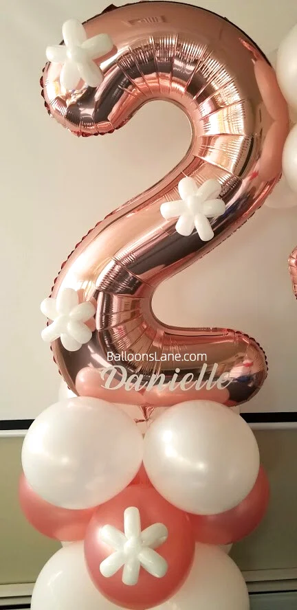 Number 2 balloon in rose gold, surrounded by rose gold and white balloons and a white flower balloon to celebrate a 2nd birthday in NYC.