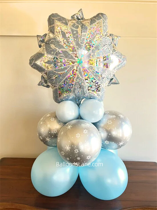 A large snowflake foil balloon featuring silver print, accompanied by blue and grey printed balloons.