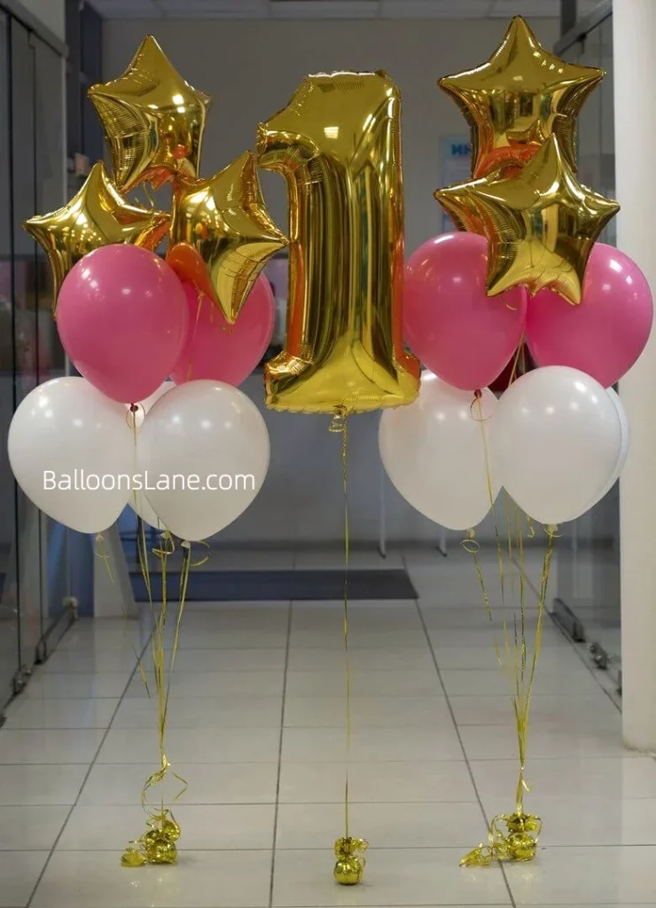 1st birthday celebration with gold star balloons and gold number balloons, accompanied by pink and white balloons to celebrate the first birthday with balloons