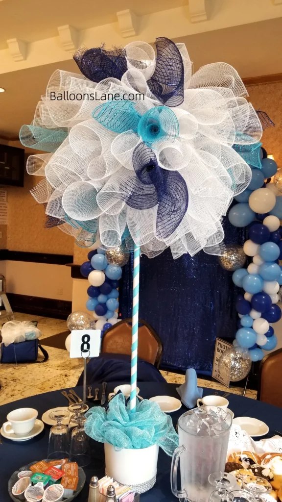 Balloon arch with blue and white balloons, accented with net flower centerpieces, in Brooklyn