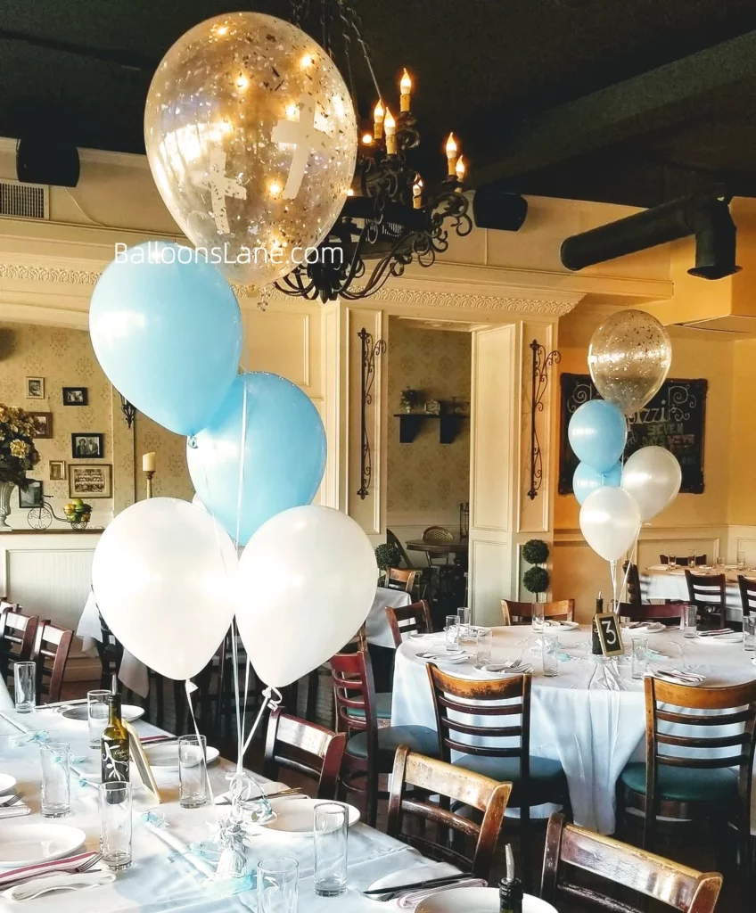 Our custom balloon arrangements feature a stunning combination of white, blue, and confetti balloons, along with a special Communion or christening big cross Mylar balloon bouquet.