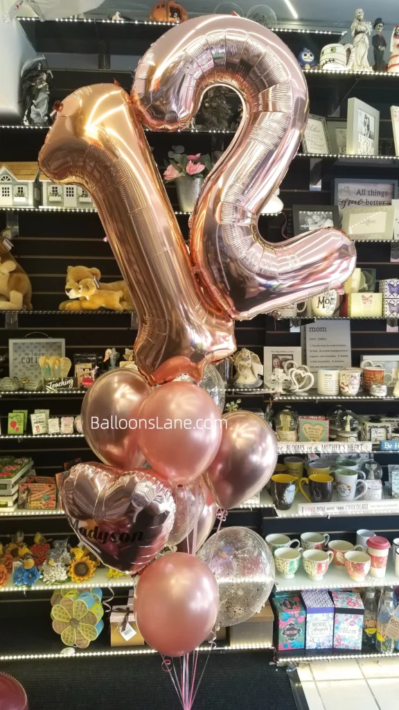 12 large rose gold number balloons with matching colored latex and confetti balloons arranged in bouquet in Brooklyn.