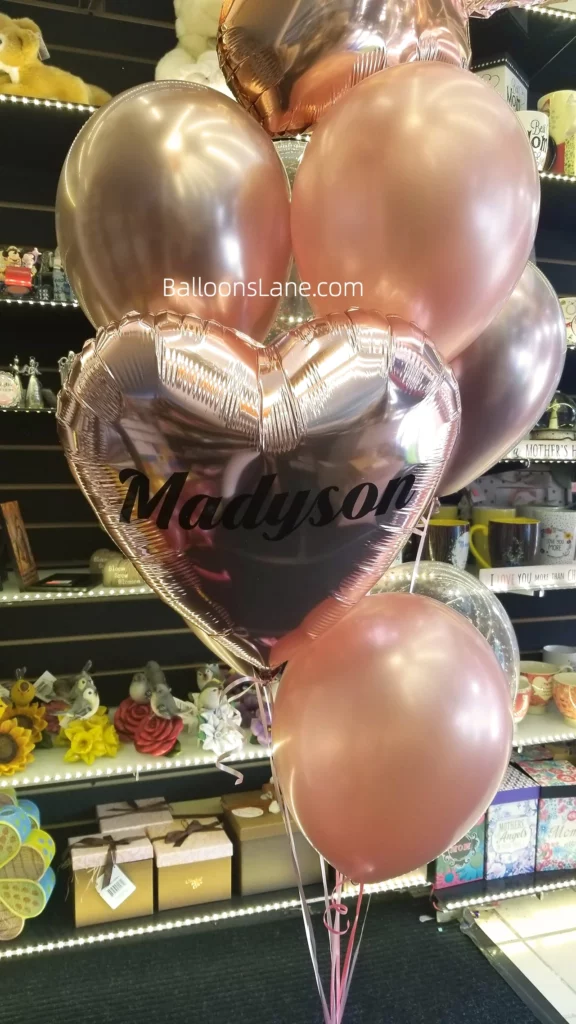 Balloon column featuring rose gold and pink balloons with personalized heart balloons.