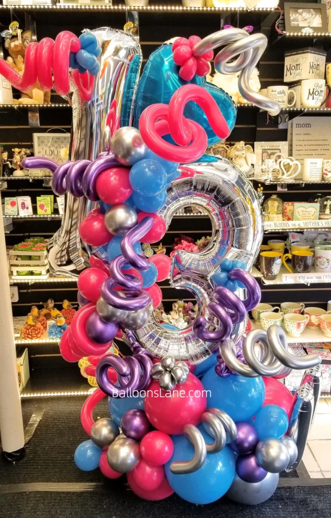 13 large silver balloons with silver twisted balloons and blue, pink, purple, and silver latex balloon bouquet to celebrate 13th birthday in NYC.