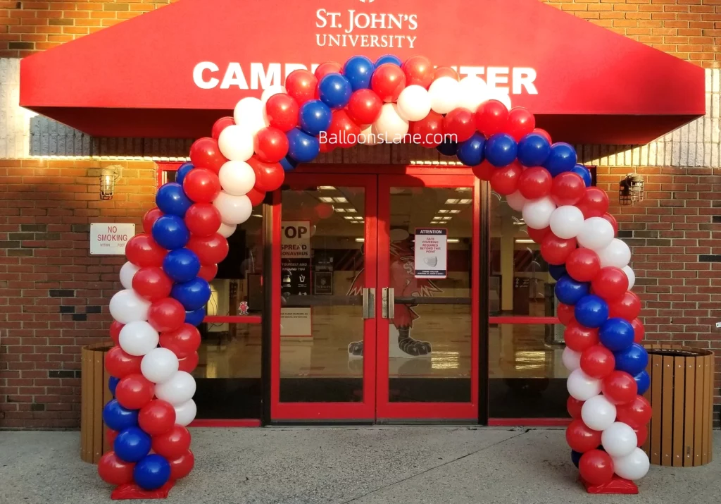 Arch made of red, white, and blue latex balloons at the front of the school.