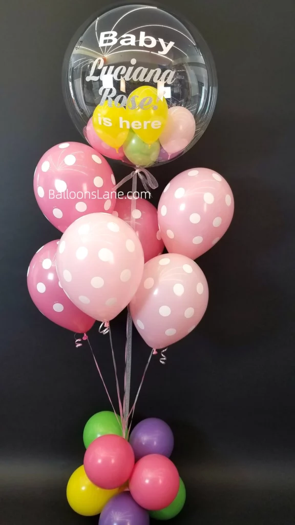 Polka dot pink balloons paired with clear customized balloons for a gender reveal party in NYC.