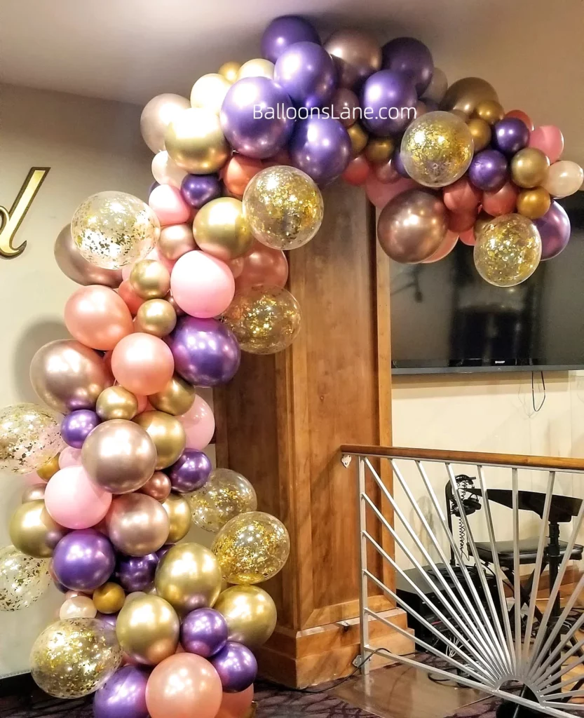 Balloon garland with pink, purple, gold, rose gold, and confetti balloons arranged for celebrations in NYC.