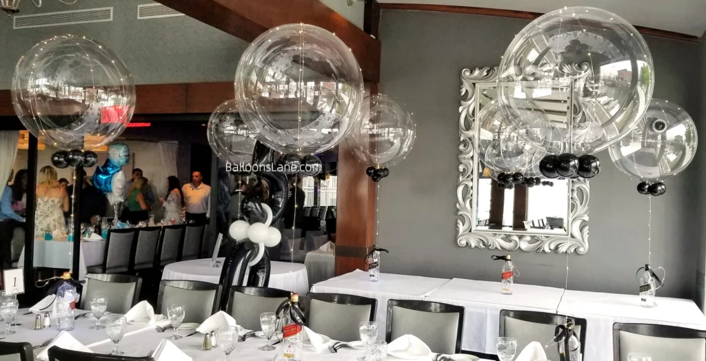 LED clear centerpiece balloons along with black and white balloons attached to bottles in New York City