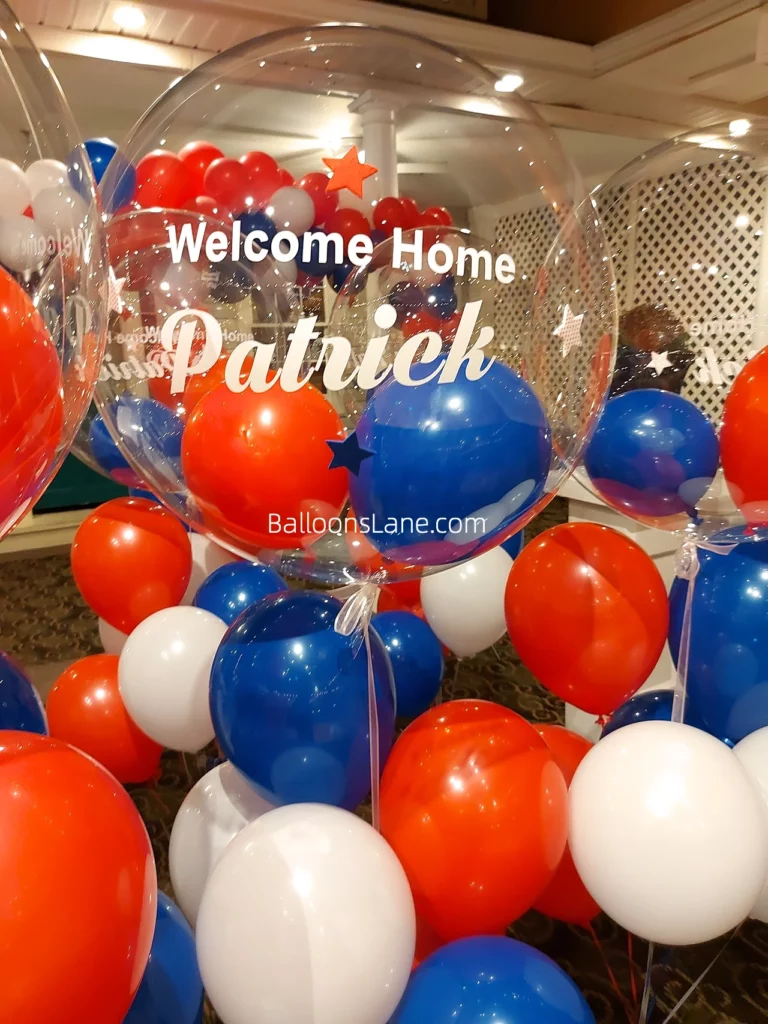 Customized clear balloon with red, blue, and white balloons spelling out "Welcome home Patrick" by Balloons Lane in NJ.