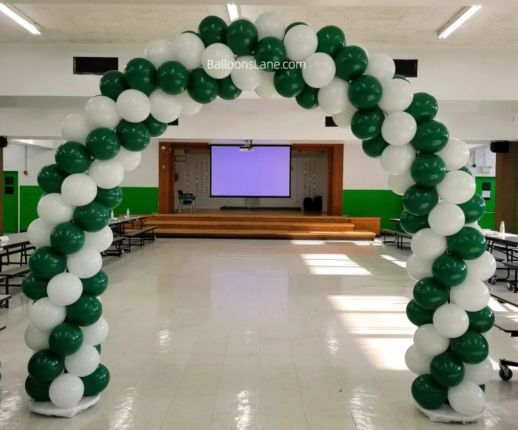 Arch made of green and white balloons at the entrance of the school.