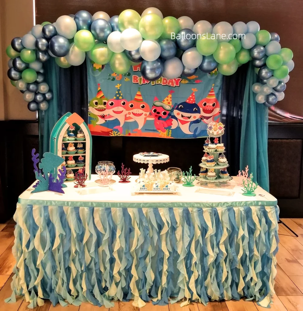 Sea theme birthday decor in NYC with mint green, chrome blue, silver, and grey balloons
