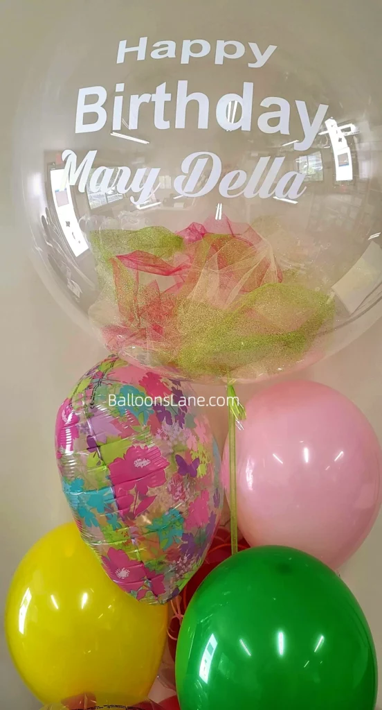 Happy Birthday Feather Clear Balloon, Pink, Yellow, Green, and Printed Latex Balloon Stand by Balloons Lane in New York