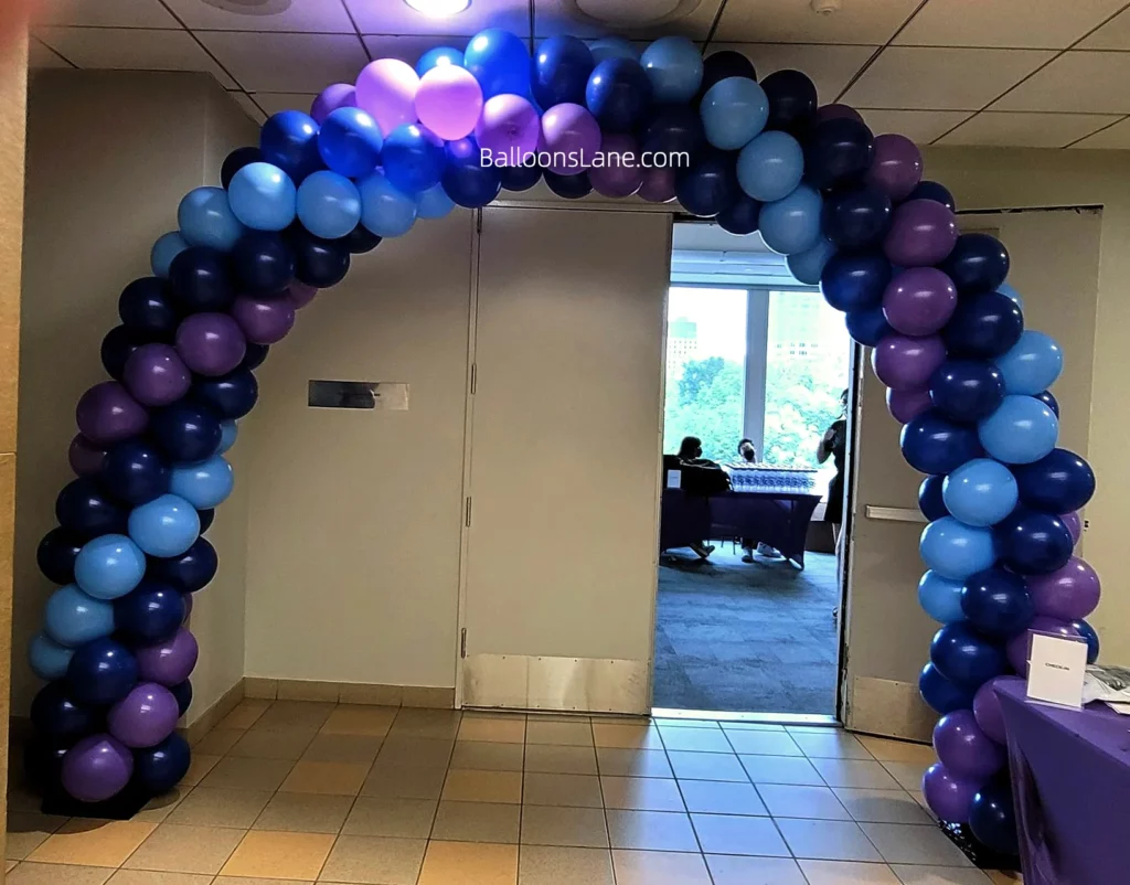 Arch made of royal blue, light blue, and purple balloons.