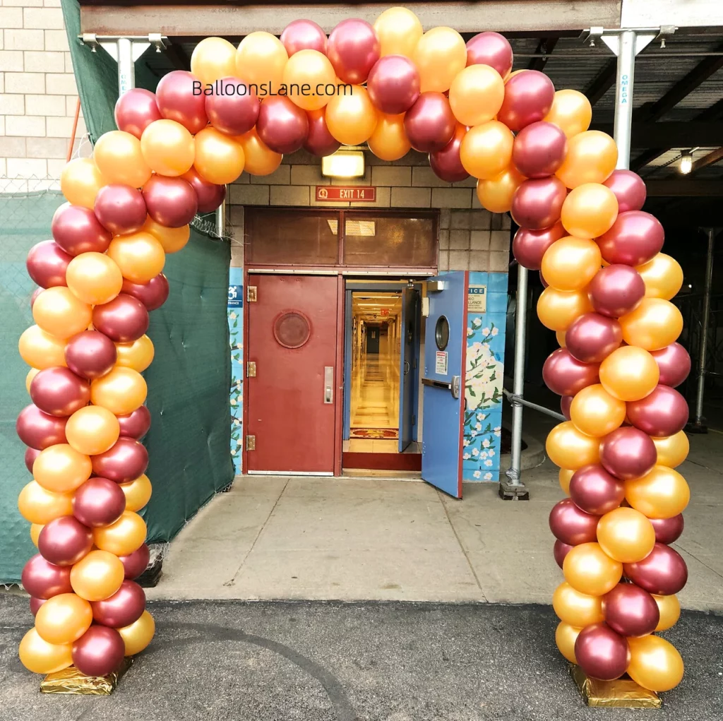 Arch made of orange and red balloons, perfect for a school celebration.