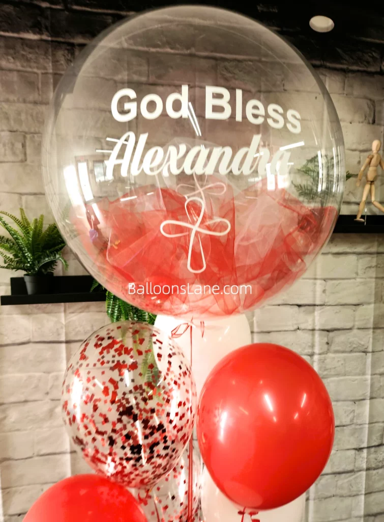 Customized balloon bouquet for "God Bless You" celebration featuring a feather balloon, red latex balloons, and red confetti balloons in NJ.