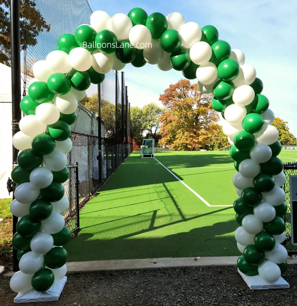 Arch made of green and white balloons.