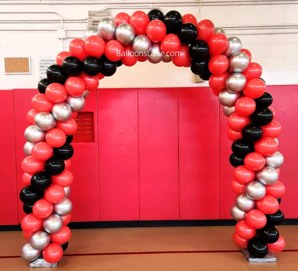 Arch made of red, silver, and black latex balloons.
