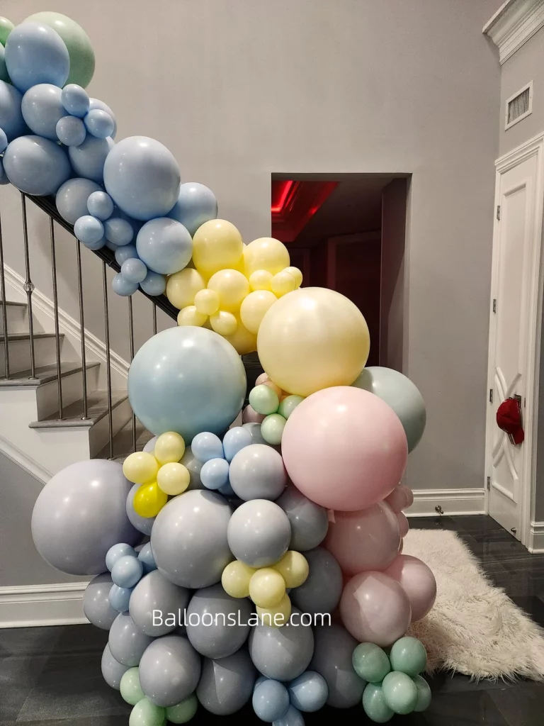Pastel Pink, Yellow, Blue, and Light Green Balloon Garland Adorning a Manhattan Staircase Alt Text: A colorful balloon garland in pastel pink, yellow, blue, and light green, decorating a staircase in Manhattan Caption: Elevate your Manhattan staircase with this vibrant pastel balloon garland featuring shades of pink, yellow, blue, and light green! Description: This image showcases a beautiful balloon garland in a variety of pastel colors including pink, yellow, blue, and light green, gracefully adorning a staircase in Manhattan. The soft hues create a charming and whimsical atmosphere, perfect for brightening up any space. Whether it's a birthday party, baby shower, or a springtime celebration, this colorful balloon decor adds a cheerful touch to the staircase, enhancing the overall ambiance of the room. Celebrate in style with this delightful pastel balloon garland in Manhattan.