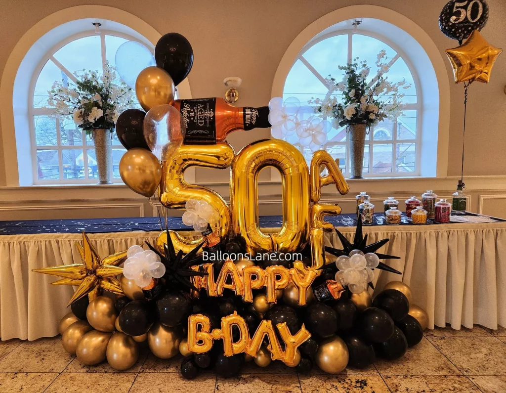 50th number balloon along with happy birthday balloon, bottle balloon, gold star balloon, gold latex balloon, black and white balloon, and 50 printed balloon all arranged in a cluster.