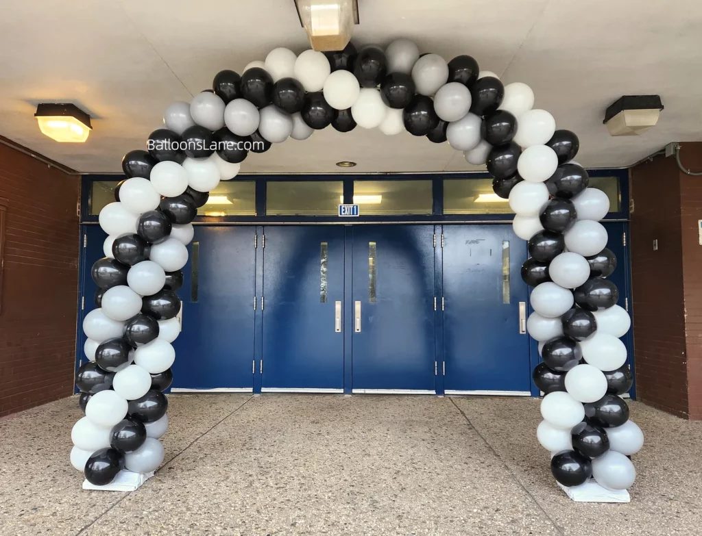 Arch made of black and white balloons.