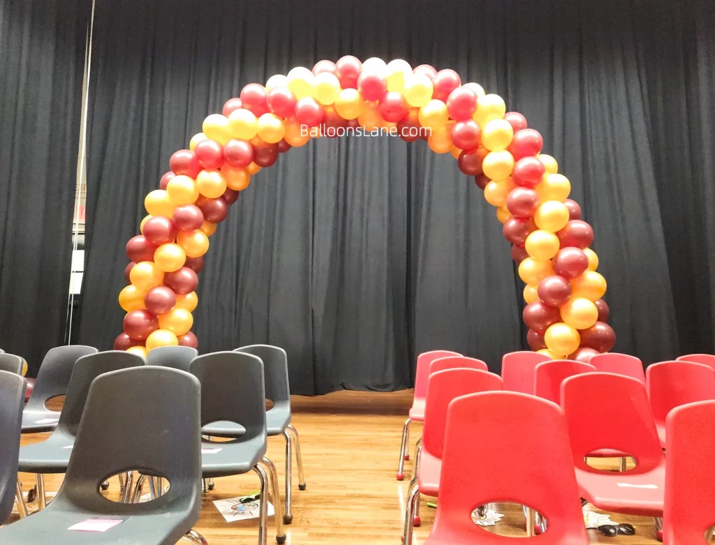 Arch made of orange and red balloons, perfect for a school celebration.