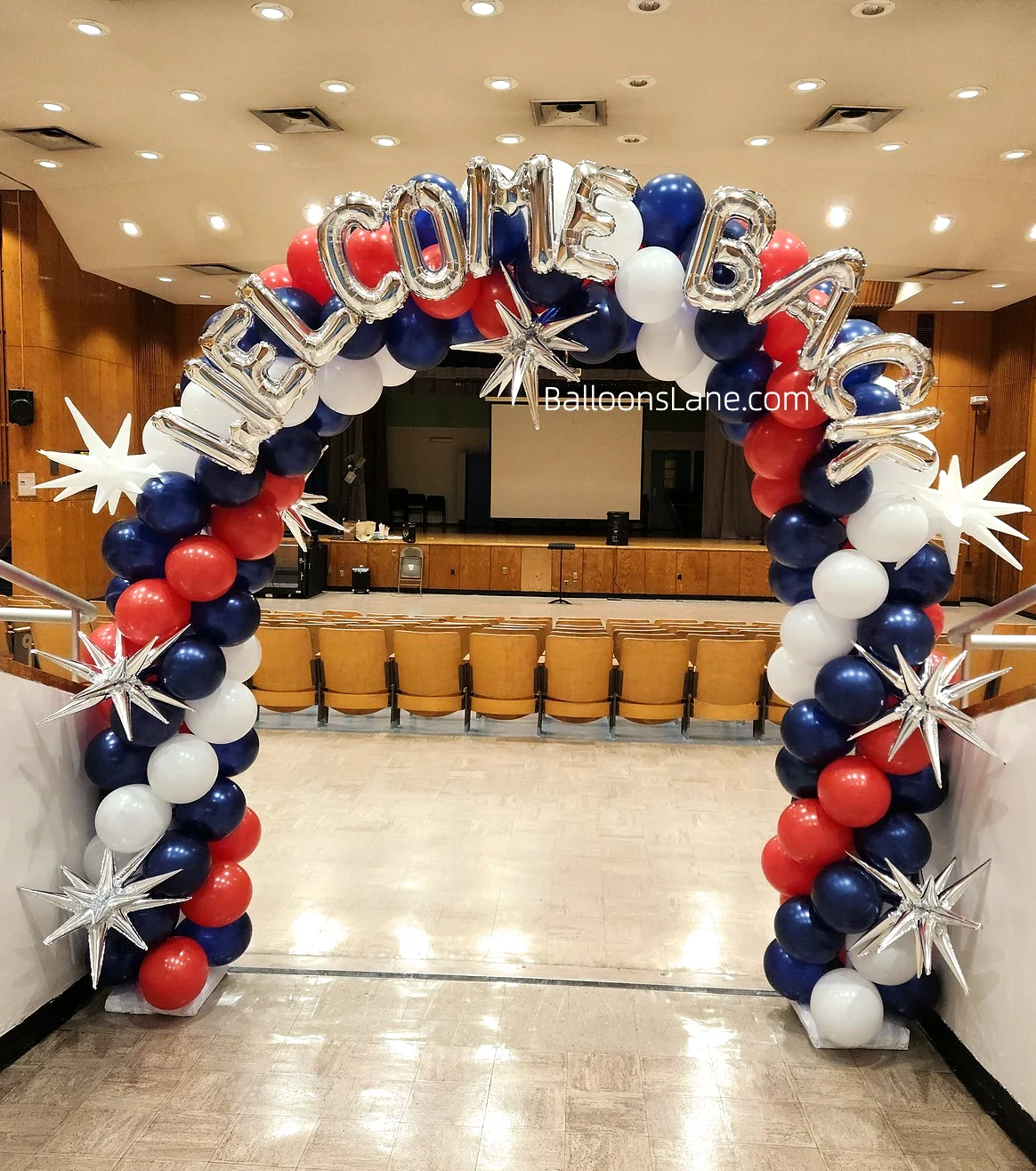 Arch made of blue, white, and blue latex balloons, with Mylar star and letter balloons, along with matching color letter balloons.
