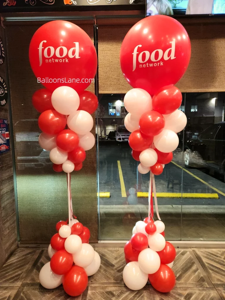 A red and white customized balloon column in NJ for corporate event celebrations.