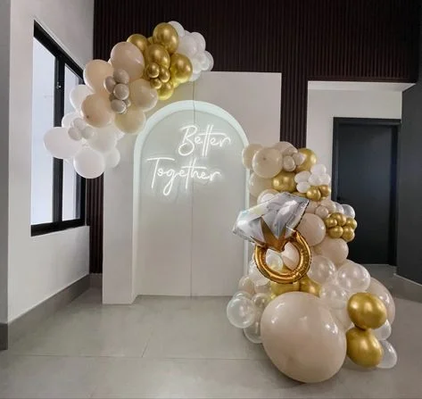 Gold ring balloon surrounded by a garland of white and pink clear balloons in Brooklyn