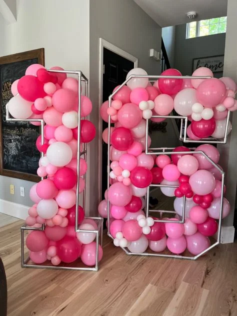 A selection of pink, white, and baby pink balloons of various sizes, perfect for a Sweet 16 celebration in NJ.