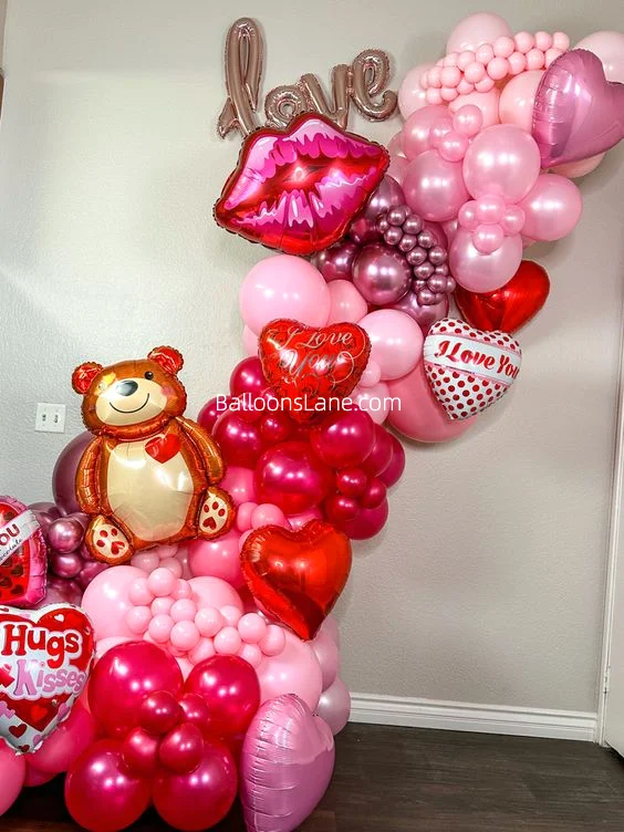 "I Love You" heart-shaped balloon and lips balloon bouquet with red and pink heart balloons.