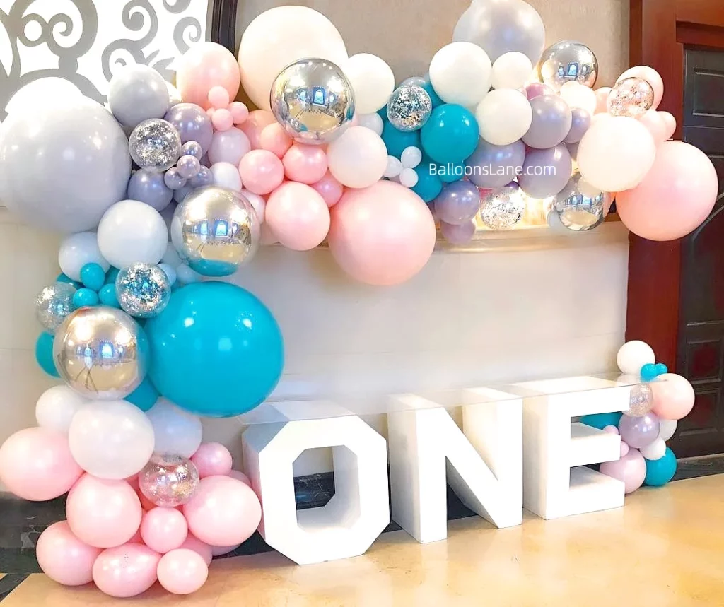 Pastel balloon garland in lavender, pink, confetti and clear balloons to celebrate a first birthday in Brooklyn.