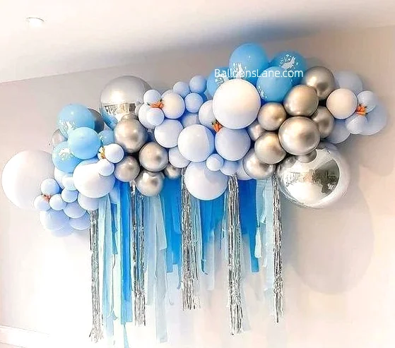 A cloud-shaped backdrop made of silver latex balloons, blue shaded balloons, and white balloons.
