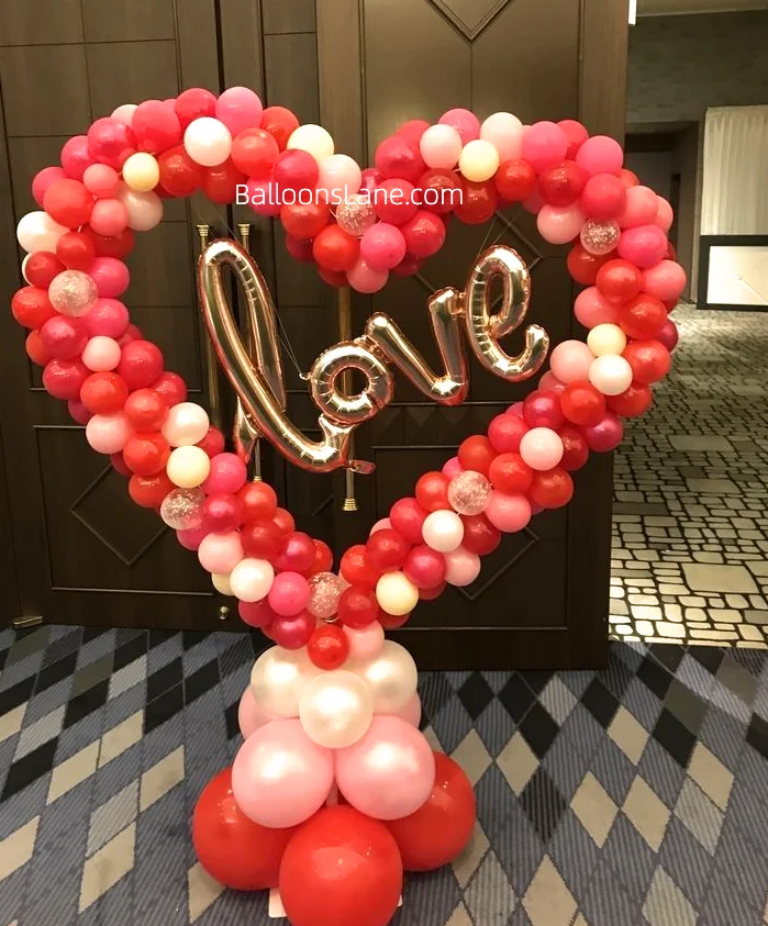 Heart-shaped balloons arranged as a backdrop with a Love Letter balloon in the center.