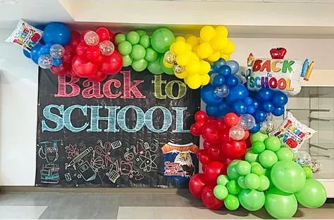 "WELCOME BACK TO SCHOOL" themed decor with red, blue, yellow, pink, and peach balloons.