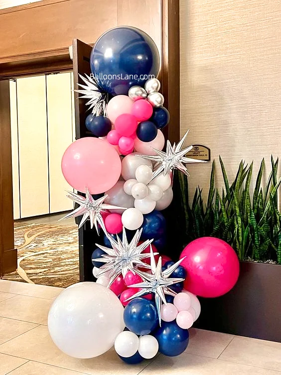 Vibrant assortments of navy blue, pink, wild Berry, white, and silver latex balloons in various sizes, accented with silver star Mylar balloons, forming a dazzling garland.
