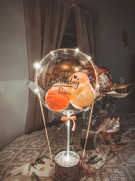LED bubble balloon along with orange textured balloon arranged in bouquet to celebrate engagement