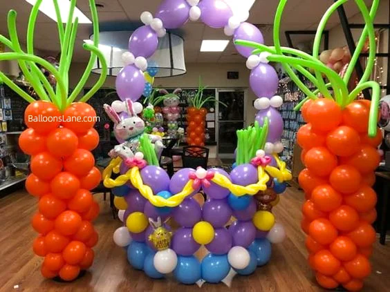 Easter balloon arrangement featuring personalized bunny basket balloons, latex balloons, Mylar balloons in purple, orange flowers, white and blue balloons, and yellow accents, arranged as backdrops, garlands, and columns in Brooklyn.