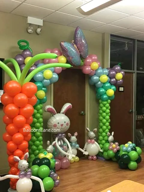 Easter-themed decor featuring green and pink flower balloons, red and green balloons, garlands with pink, yellow, and purple balloon flowers, and themed decorations, set in NJ.