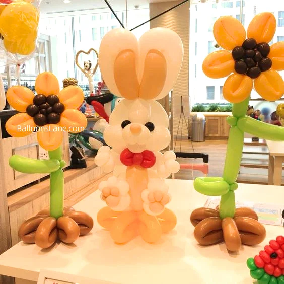 Bunny balloon crafted from white and yellow twisted balloons, accompanied by orange, green, and brown twisted balloons to celebrate Easter in Brooklyn.