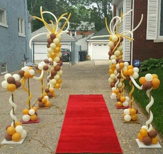 Elegant latex balloon columns in yellow, white, and brown are designed to decorate the entrance and pathway for a warm and inviting ambiance.