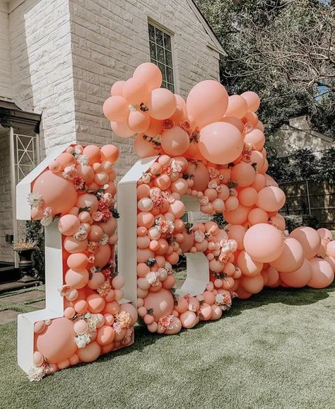 Grand celebration of Sweet 16 with blush pink balloons backdrop featuring multiple sizes of balloons in NYC