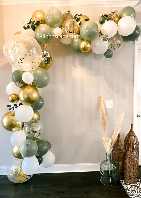 Half arch of emerald green, white gold, and gold latex balloons, adorned with confetti balloons, to celebrate a birthday engagement in NY.